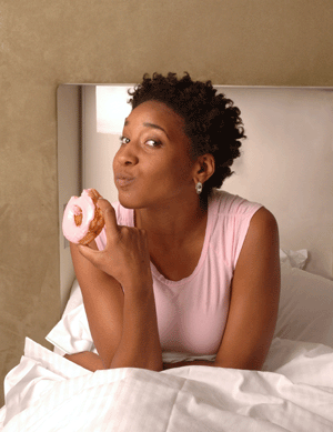 woman with food craving eating doughnut