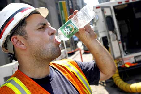 A worker chugs water on a hot day in New York in 2006.