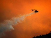 A firefighting helicopter drops water over the Gap Fire on July 3, 2008, near Goleta, Calif. 