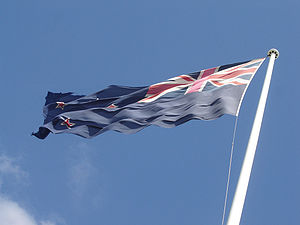A large national flag flies over Auckland International Airport.
