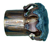 A fired .38 Special hollow-point bullet viewed from the side, showing the intended terminal ballistics sometimes referred to as mushrooming.