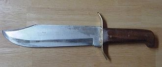 A typical bowie knife, with its hallmark large blade and unique shape. This knife became popular because of its utility as a weapon and as a tool for camping, fishing and hunting.