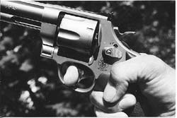 High hand grip, thumb curled down for strength, index finger at distal joint on trigger for maximum leverage. This is the grasp author used to win IDPA NH State Championship in 2003 with this stock service revolver, S&W’s .45 caliber Model 625.