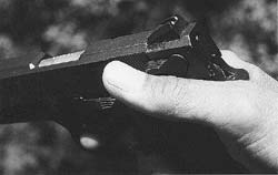 With a slide mounted safety as on S&W Model 457 compact .45, shown, author prefers this grasp, with thumb at upward angle to guarantee release of safety catch.